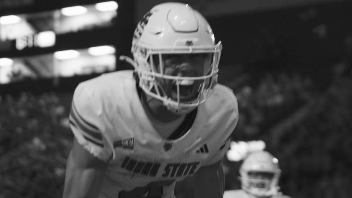 Black and white photo of an Idaho State football player in a ready position during a game